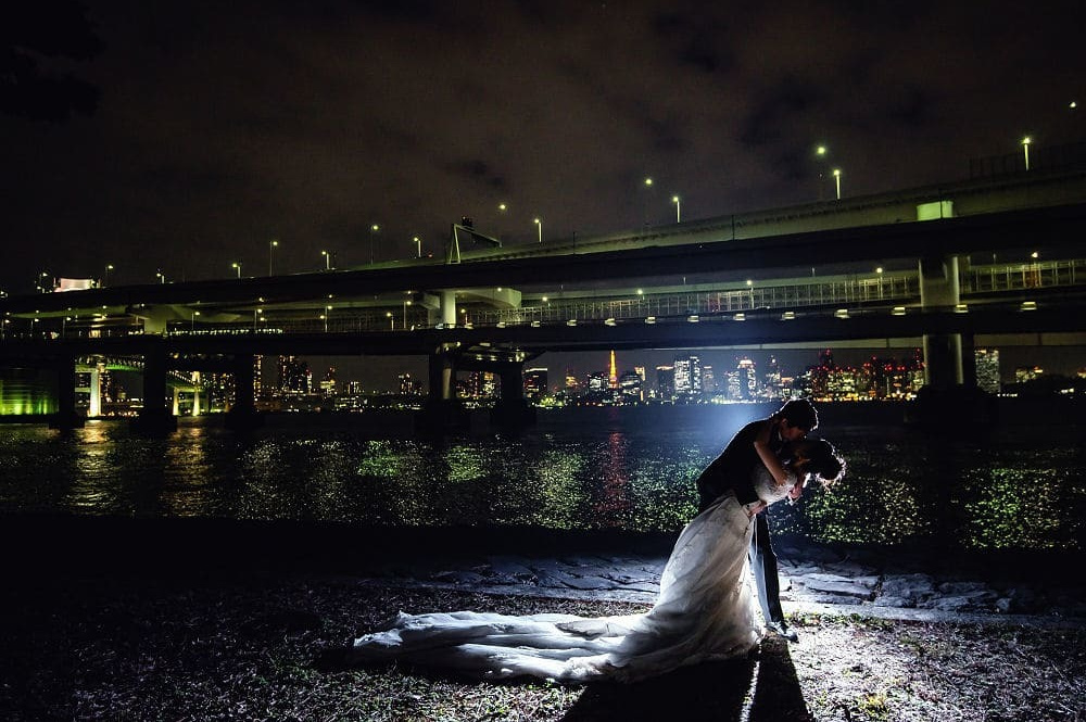 大さん橋で夕焼けをバックに新婦を持ち上げる新郎